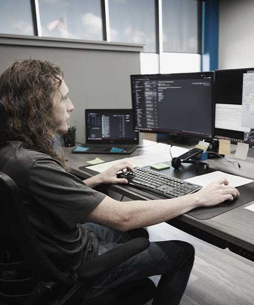 JMag employee working on computer at desk
