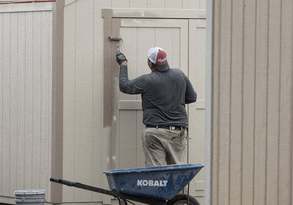 Eagle Ridge Barn Builders worker painting a new shed